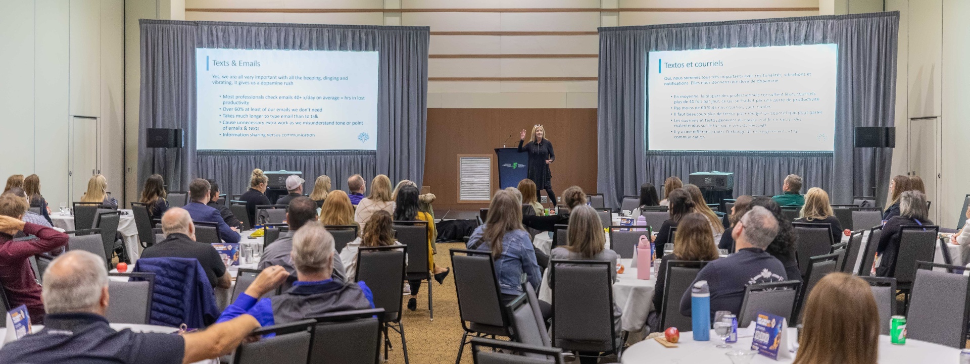 Jen DeWare on stage delivering a talk to a packed conference audience
